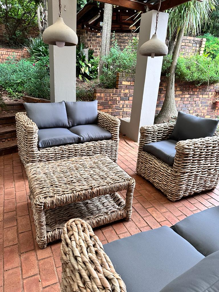 1-seater grey cushion wicker couch with other wicker couches nearby
