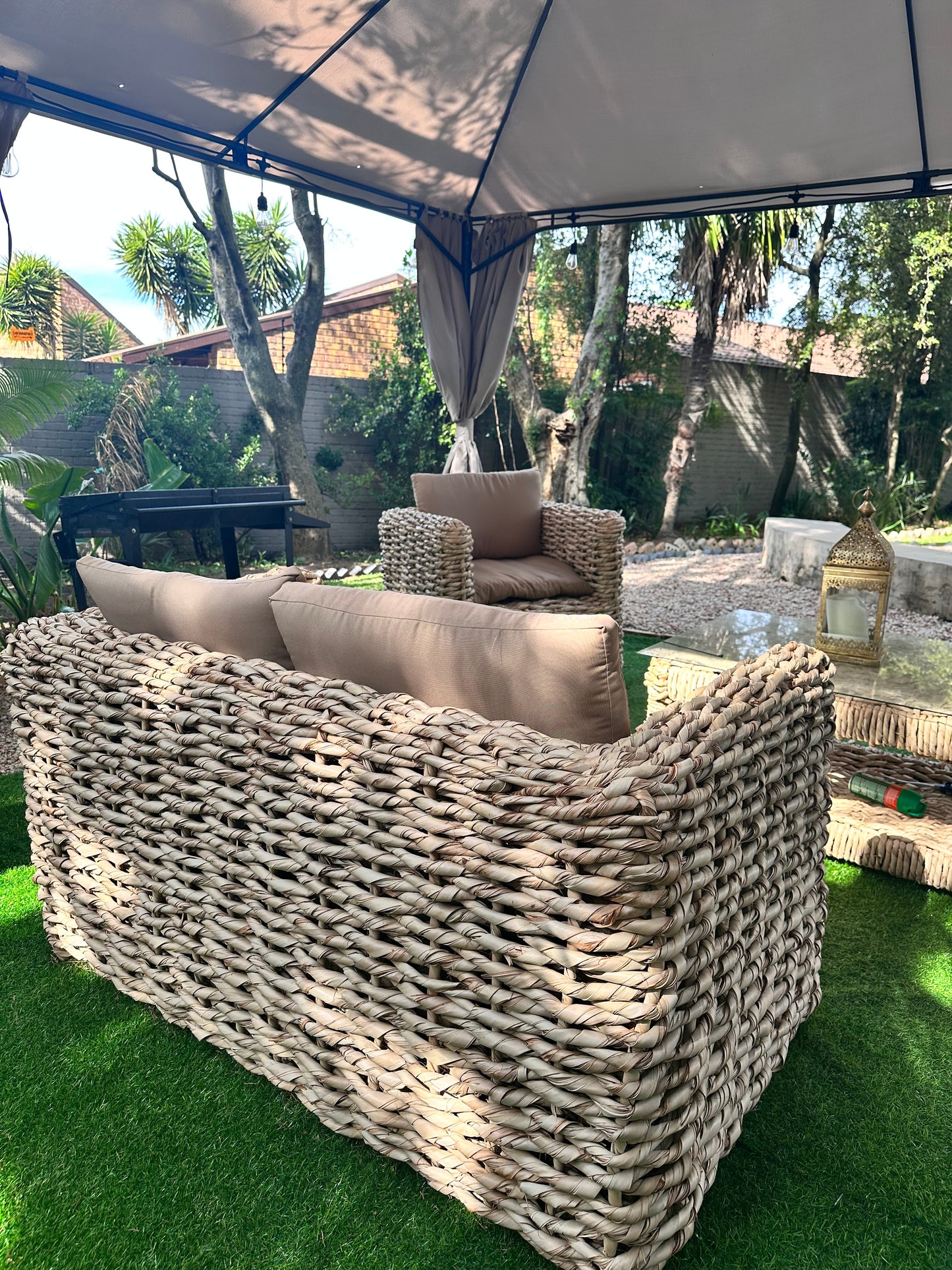 1-seater beige cushion wicker couch with other wicker couches nearby