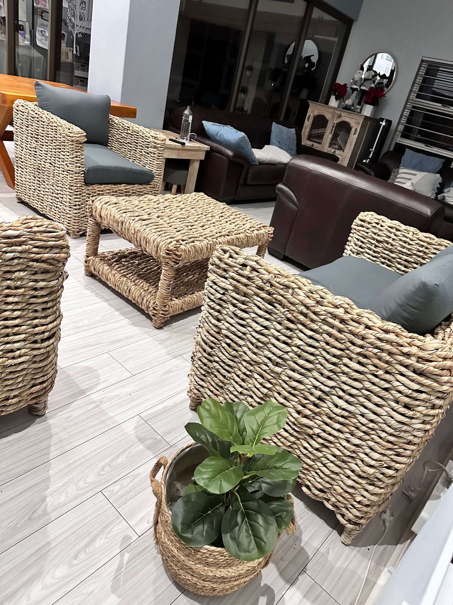 1-seater grey cushion wicker couch with other wicker couches nearby