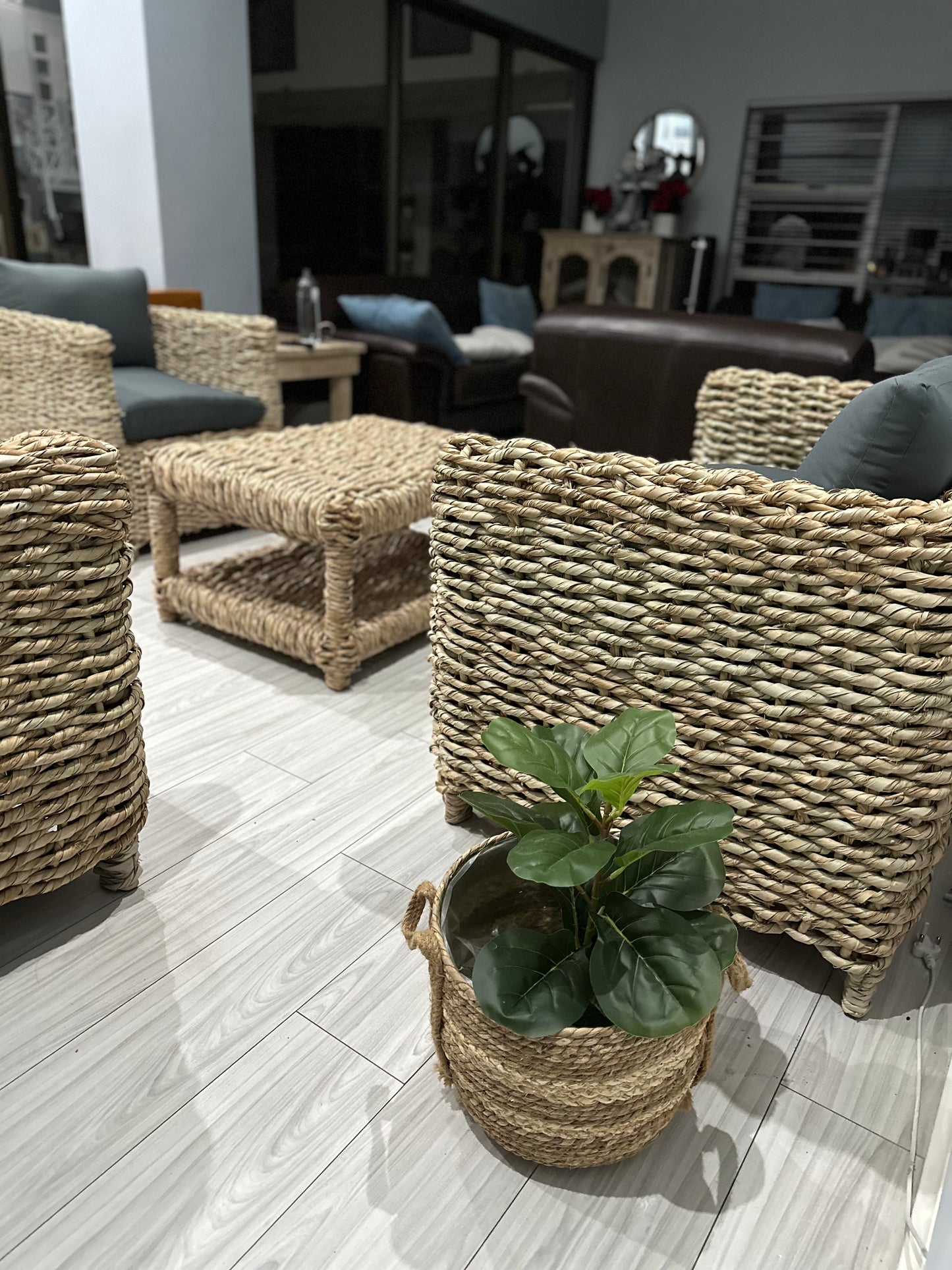 1-seater grey cushion wicker couch with other wicker couches nearby