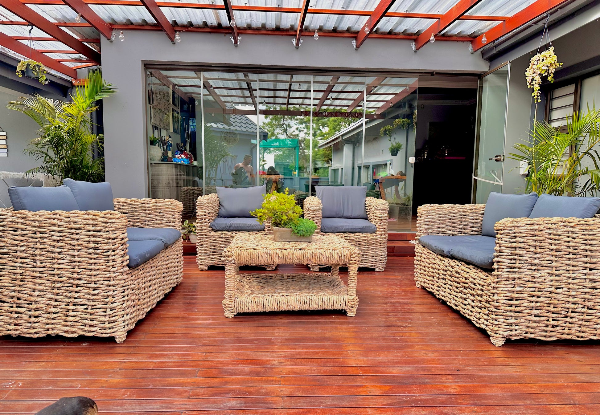 A grey cushion wicker lounge suite that made up of 2 double seaters and 2 single seaters with a coffee table