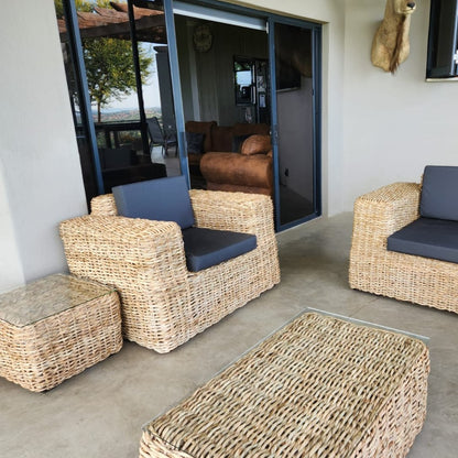 Elegant Amara 1-seater wicker couch with soft cushions in a stylish outdoor setting.