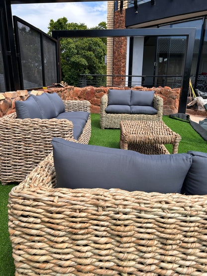 A 3-2-2 coffee table wicker lounge suite with grey cushions