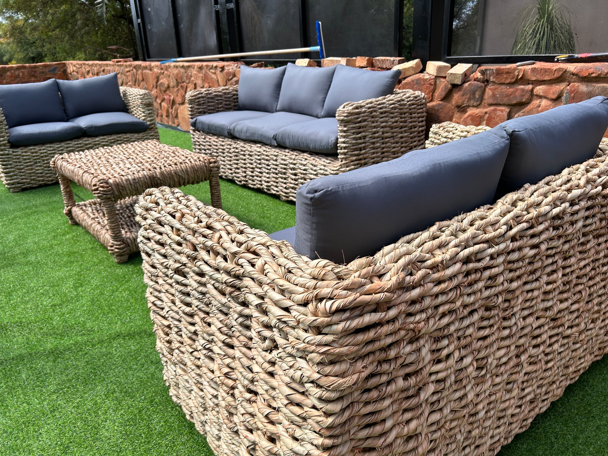 A 3-2-2 coffee table wicker lounge suite with grey cushions