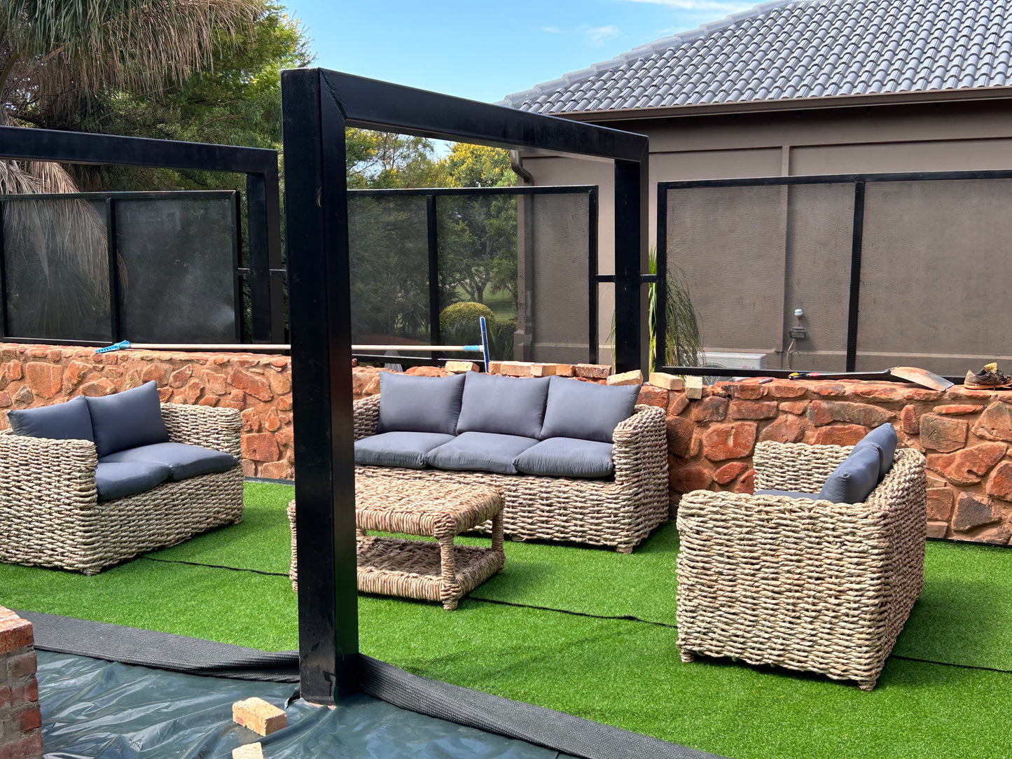 A 3-2-2 coffee table wicker lounge suite with grey cushions